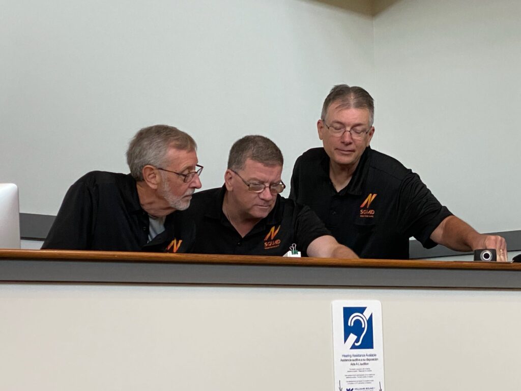 3 men working on a panel